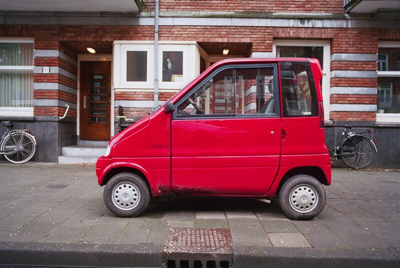 A microcar in its native element — an Amsterdam sidewalk.